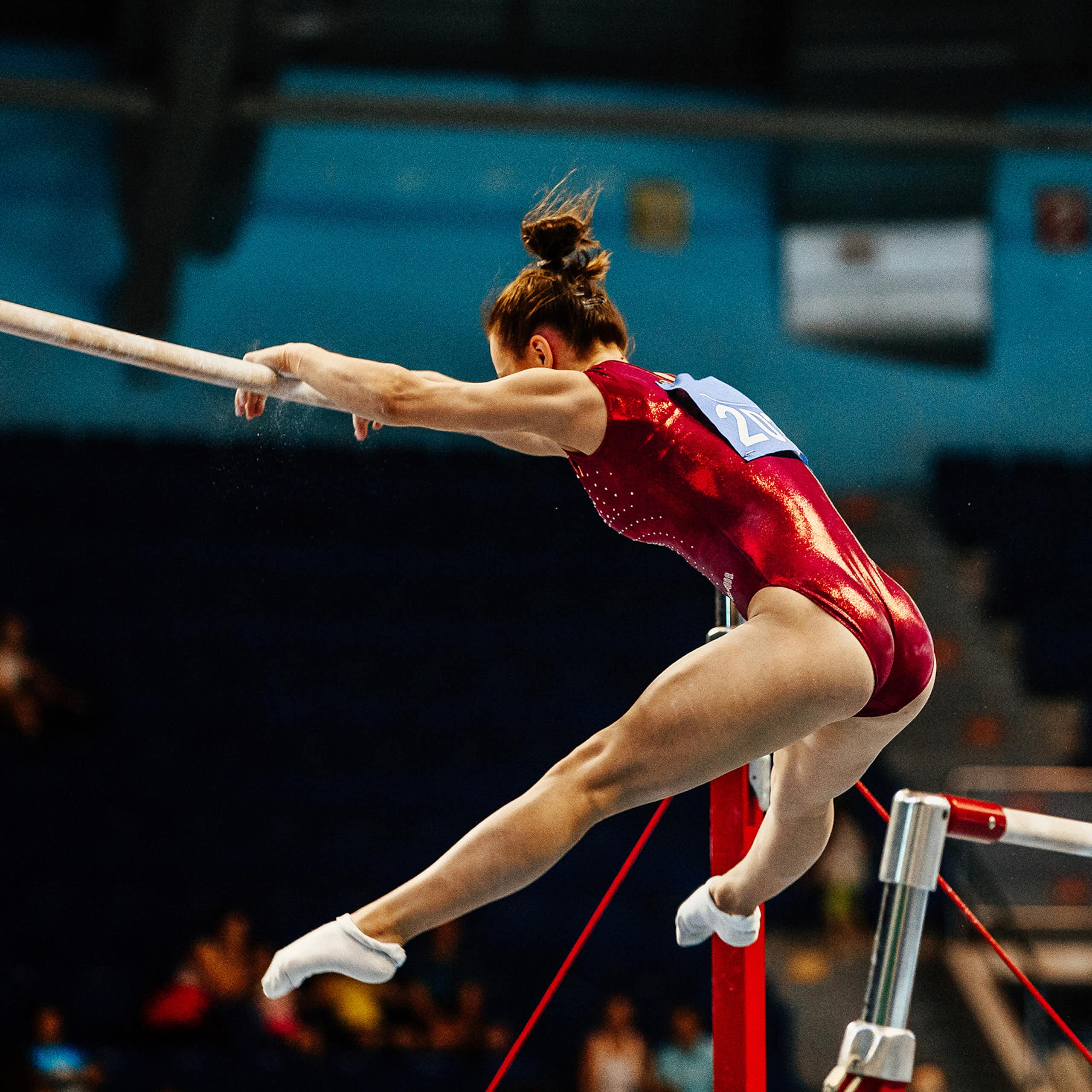 Une gymnaste effectue un exercice sur des barres asymétriques lors d'une compétition.