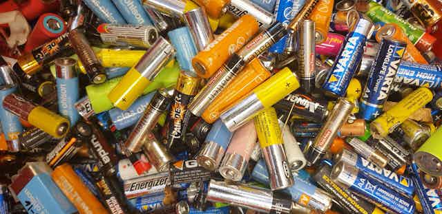 a jumble of different color and size household batteries