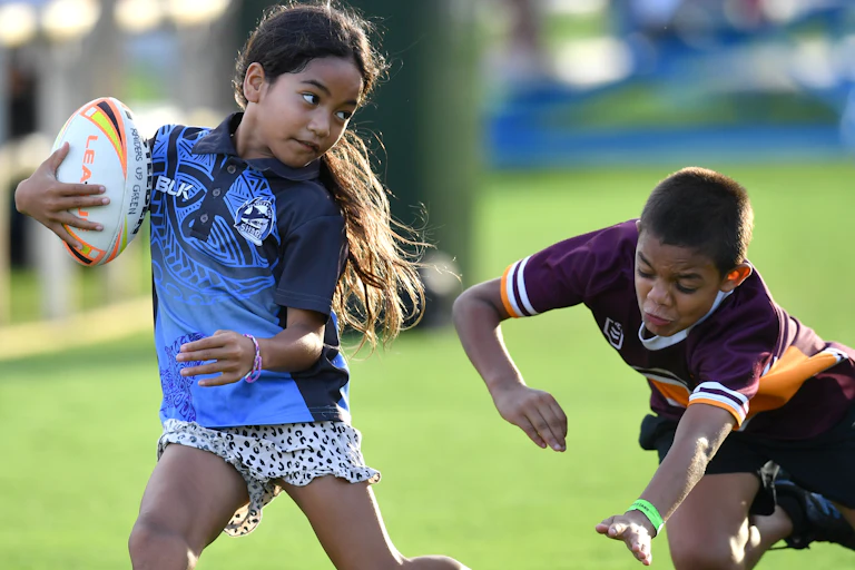 Two children having fun playing rugby league