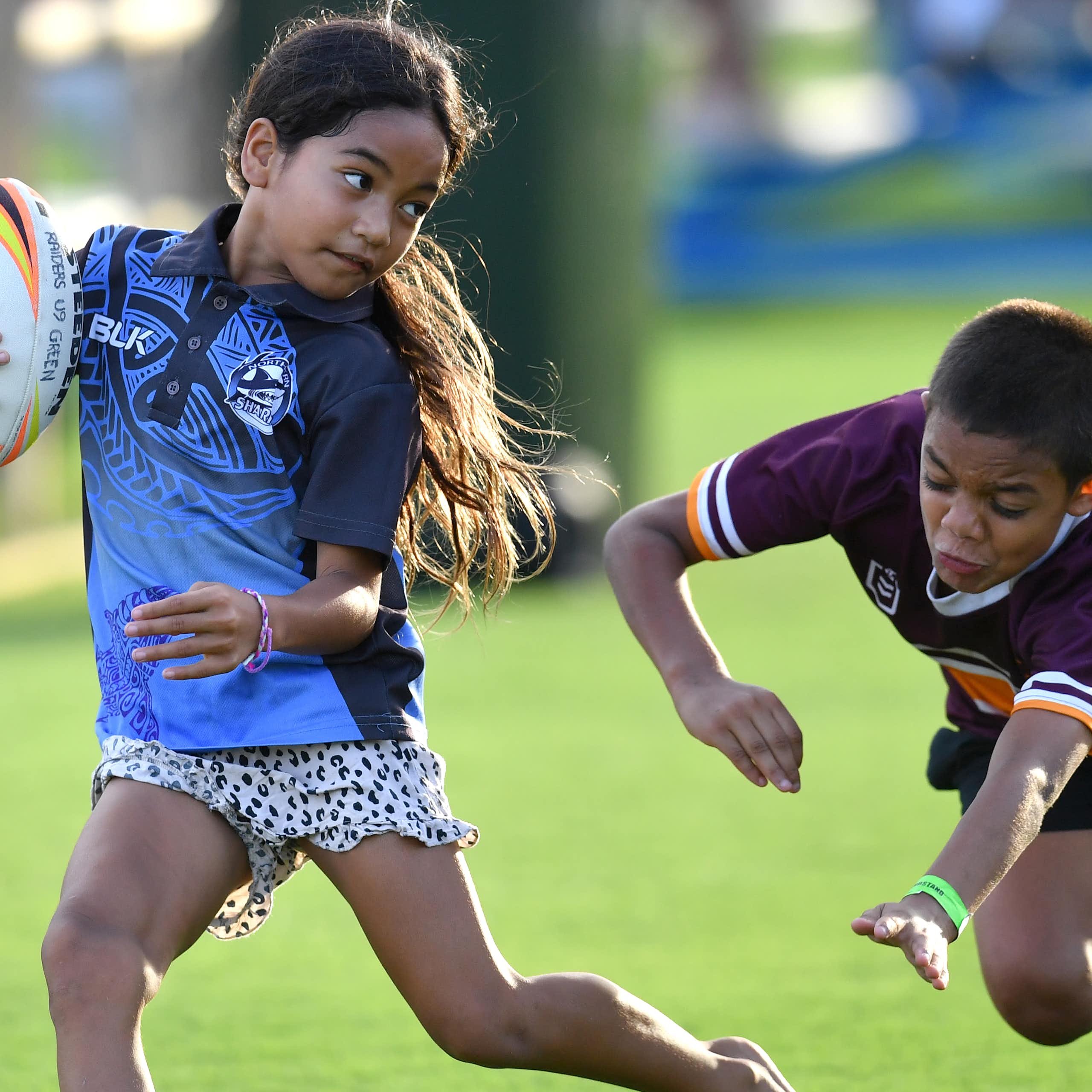 Two children having fun playing rugby league