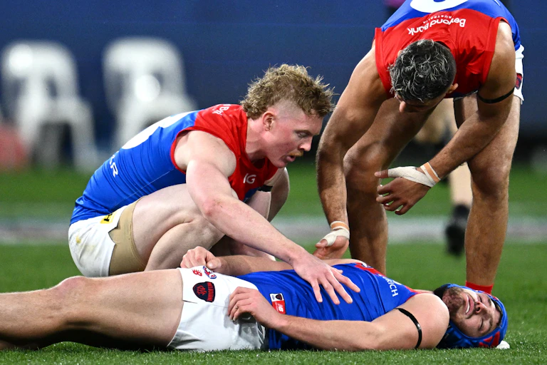 AFL player Angus Brayshaw lays concussed on the ground