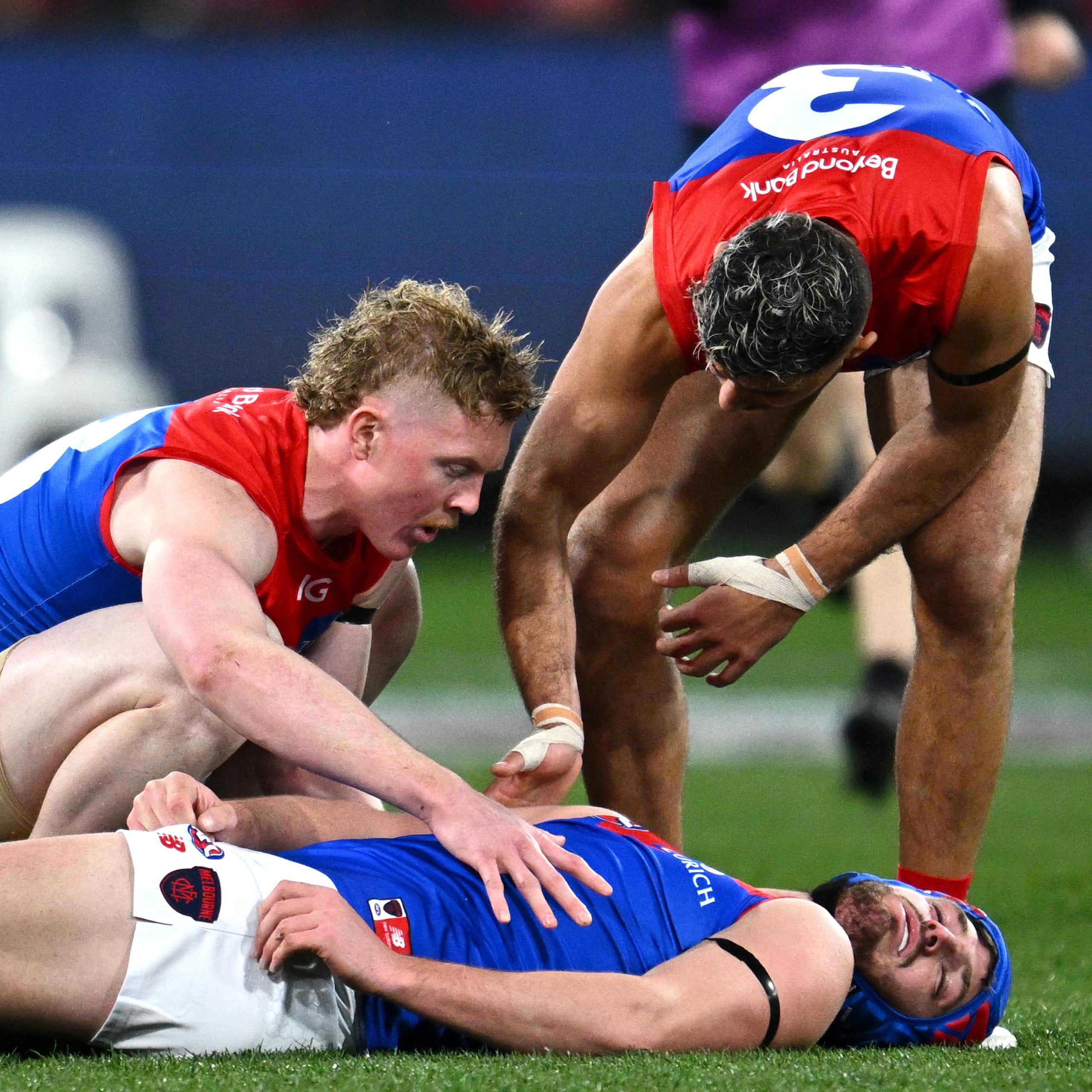 AFL player Angus Brayshaw lays concussed on the ground