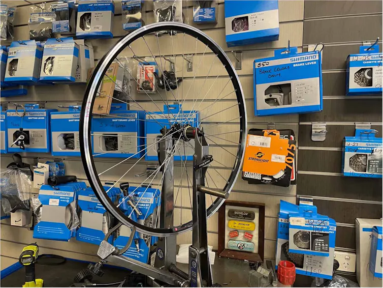 Photo of a bike wheel on a truing stand.