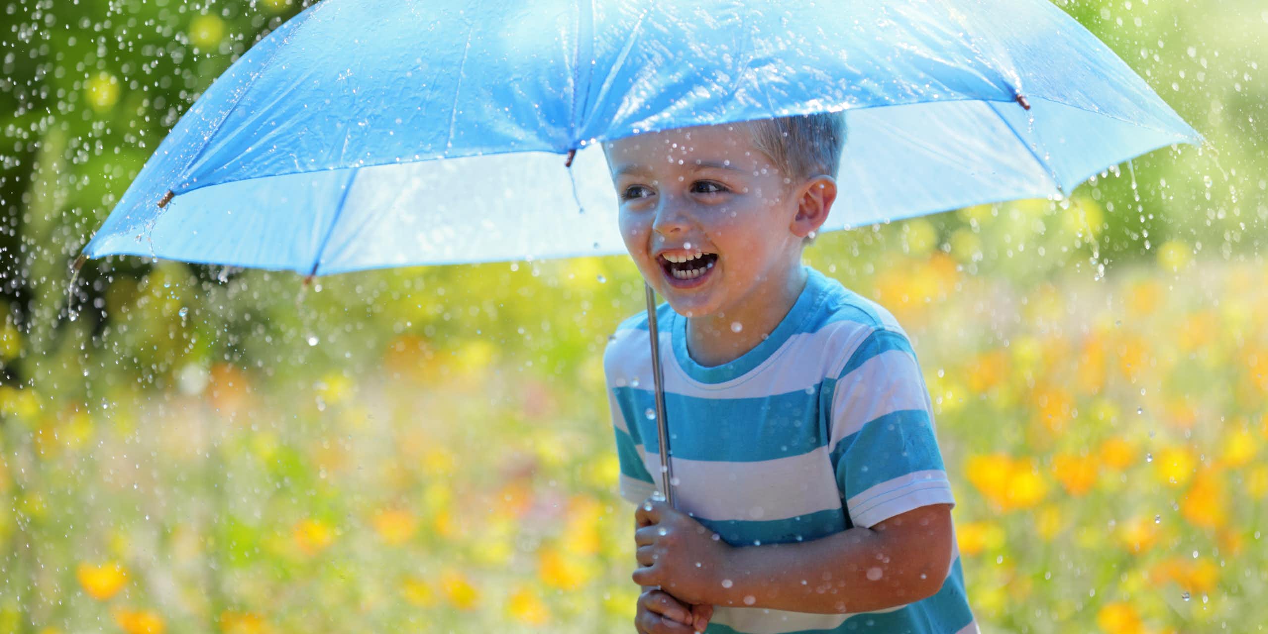 Boy holds umbrella in rain