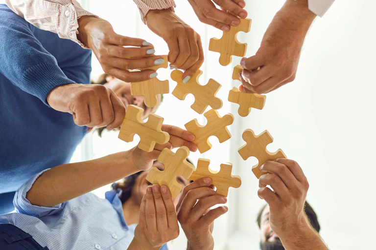 Lots of people holding up jigsaw pieces