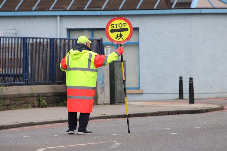 A lollipop man on a street.