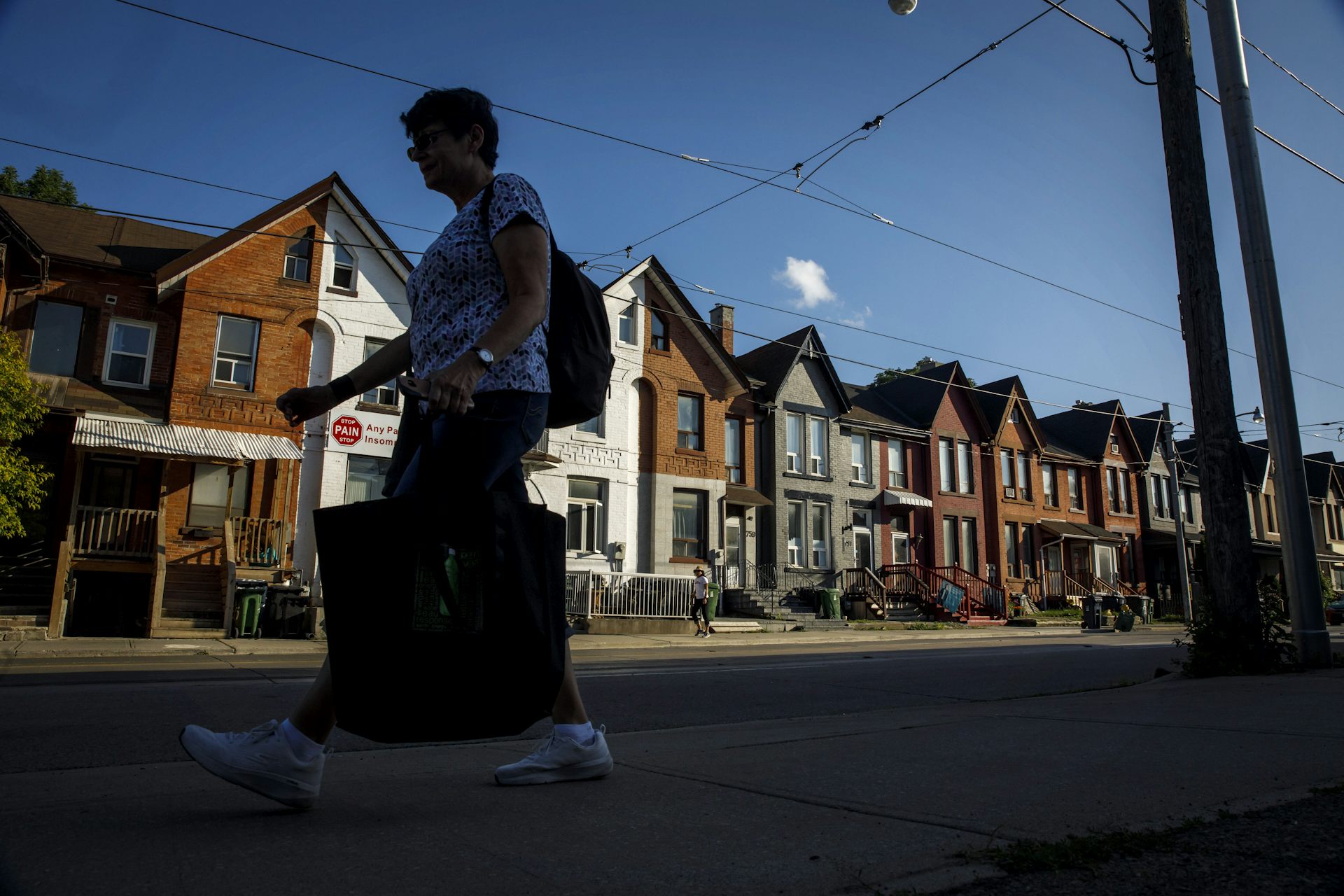 A person walks by a row of townhomes.