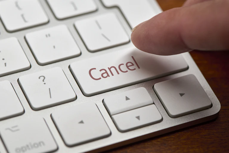 A white keyboard with a finger about to press cancel.