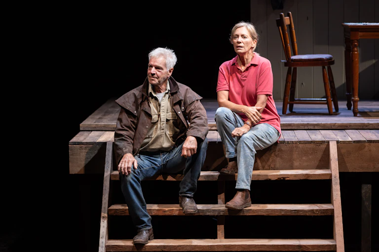 Production image: a couple sit on wooden steps