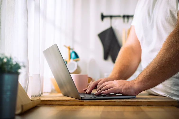 Man types on laptop