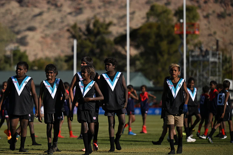 Young AusKick players walk off the field at Traeger Park in Alice Springs