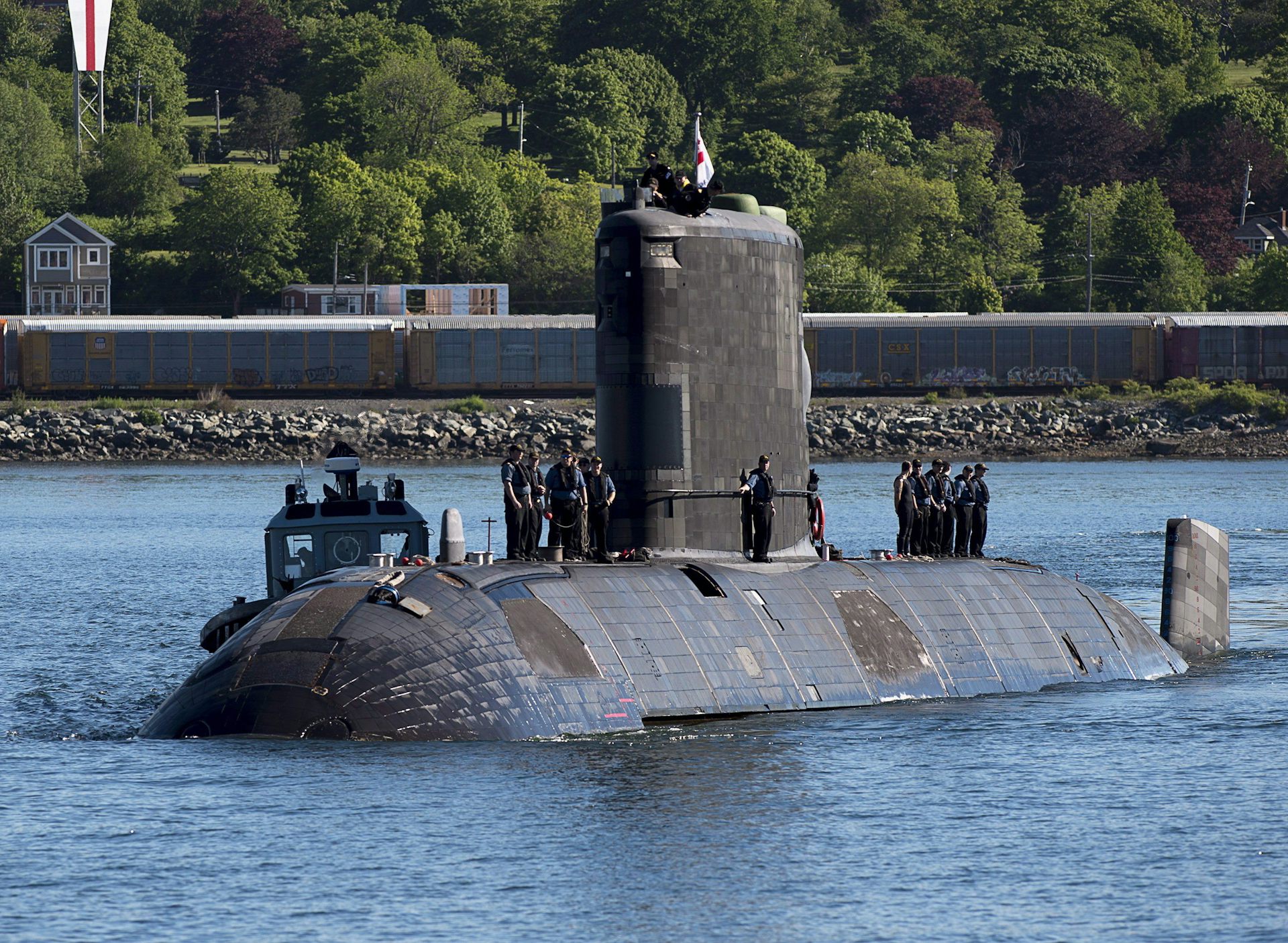 The top of a submarine is seen in a body of water.