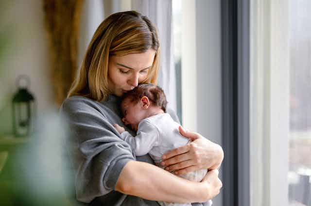 A woman holding a newborn baby.