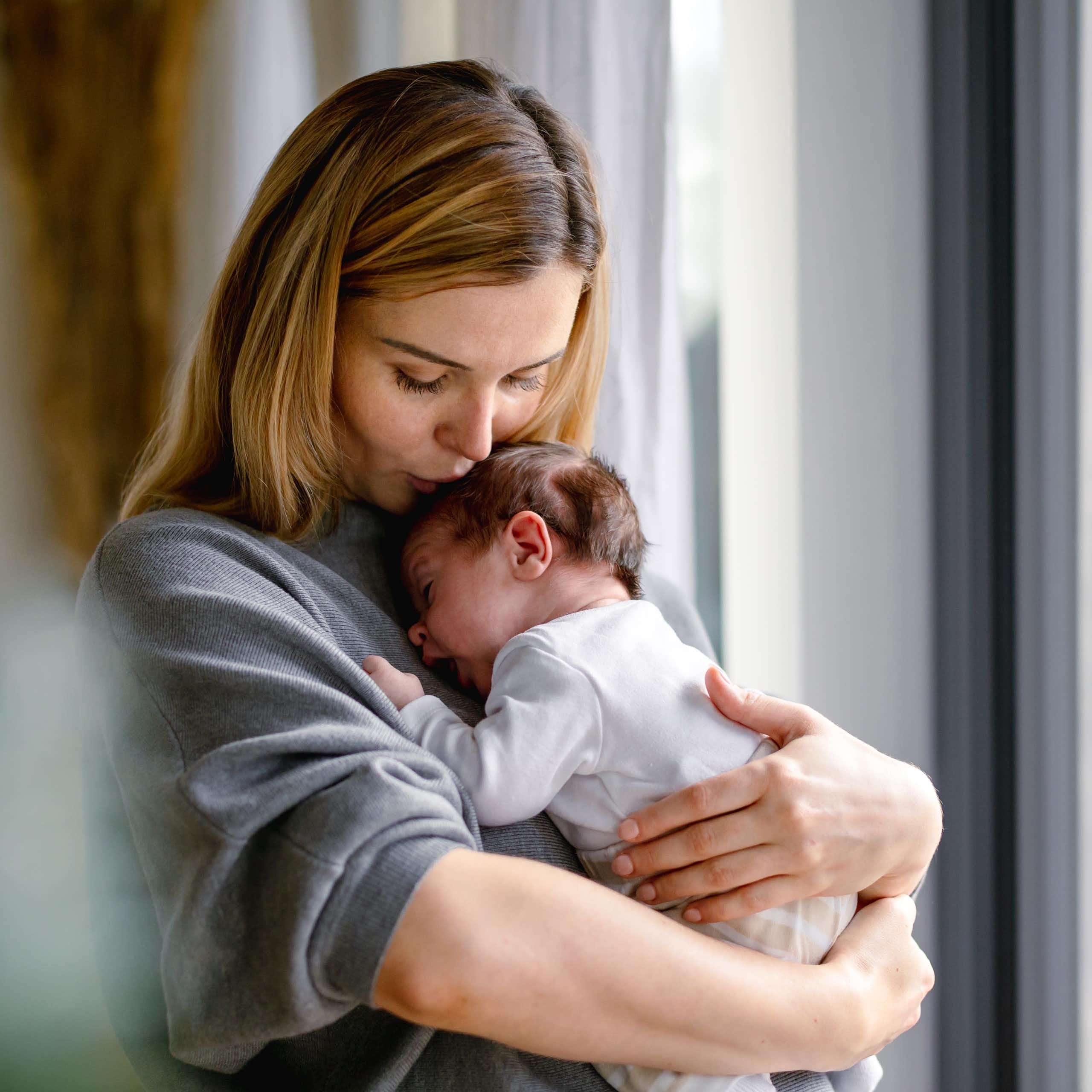 A woman holding a newborn baby.