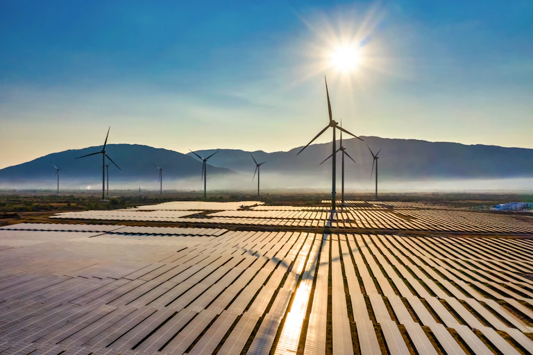 Aerial view of windmills and solar panels with bright sun in the sky at Bac Phong, Thuan Bac, Ninh Thuan, Vietnam