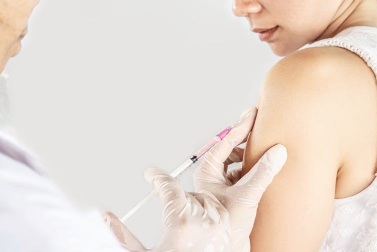 A woman gets an injection from her doctor or nurse.