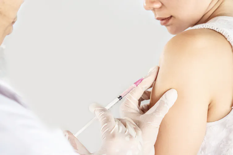 A woman gets an injection from her doctor or nurse.