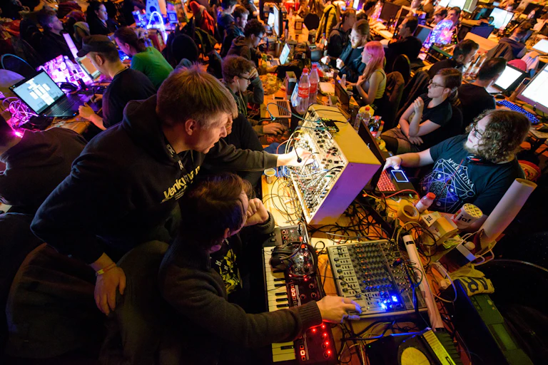 Technology enthusiasts work on modular synthesizers at an analogue tech festival