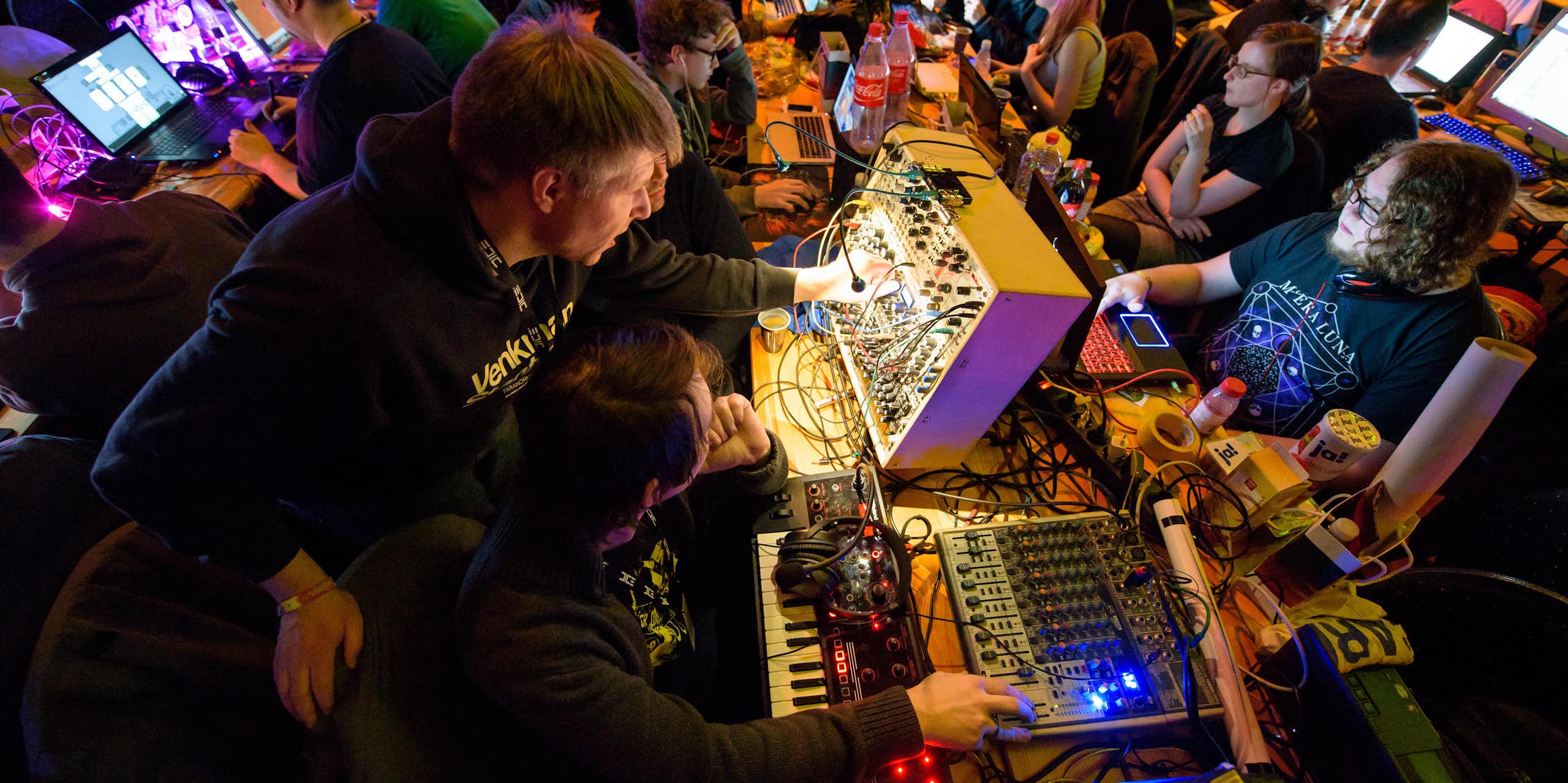 Technology enthusiasts work on modular synthesizers at an analogue tech festival