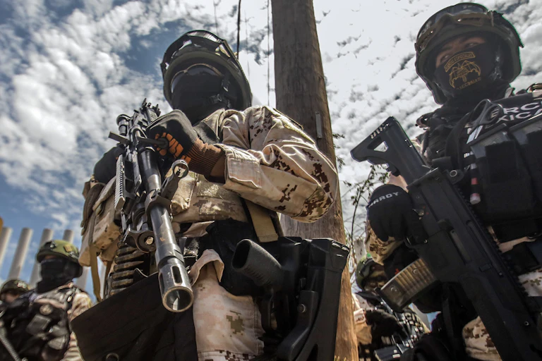 Members of the Mexican army holding guns and wearing balaclavas.