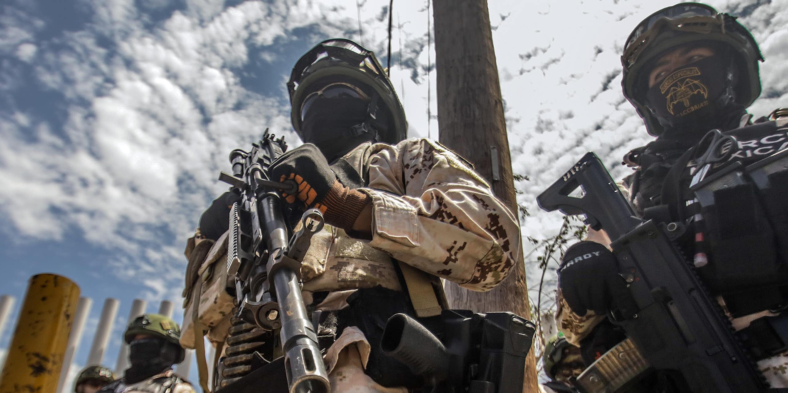 Members of the Mexican army holding guns and wearing balaclavas.