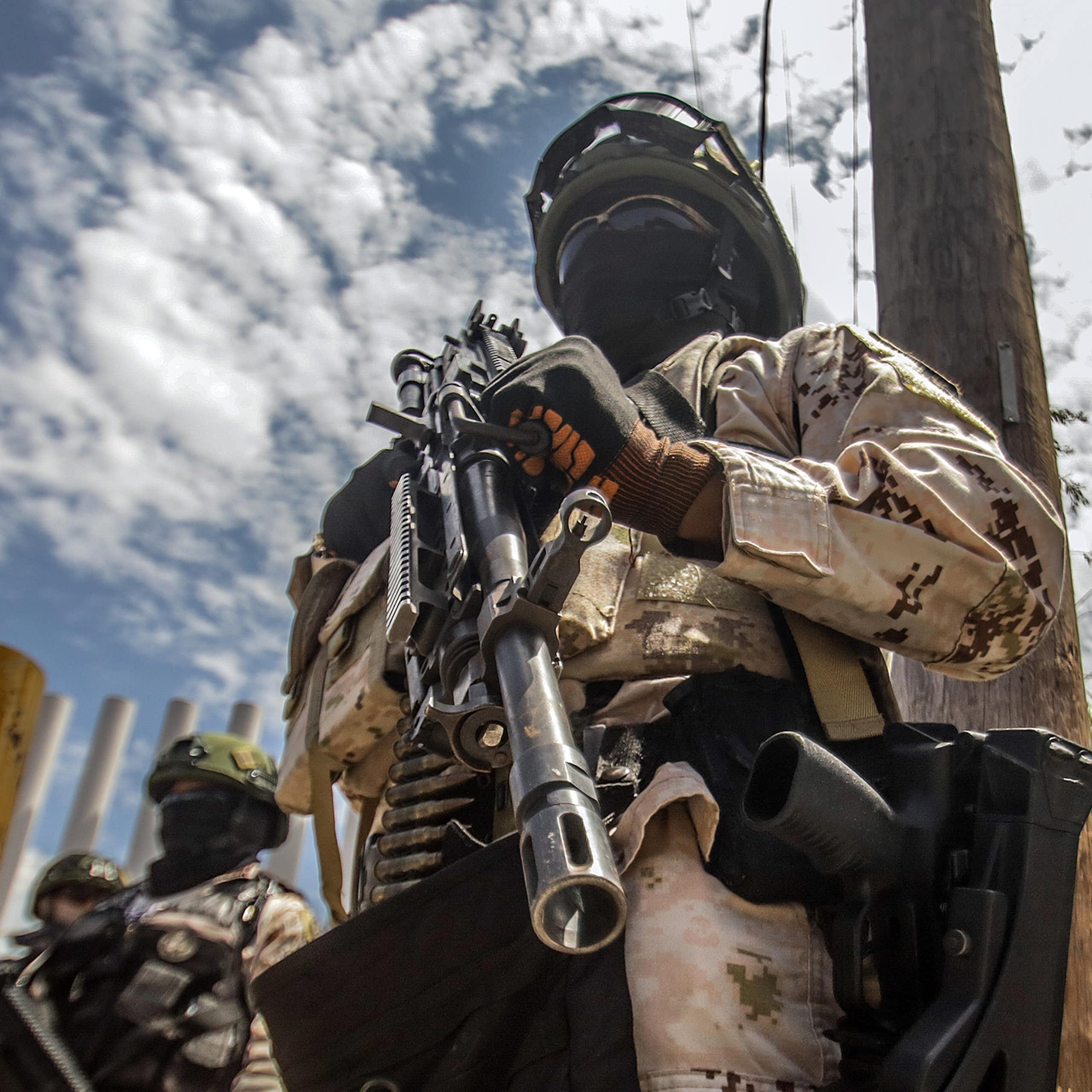 Members of the Mexican army holding guns and wearing balaclavas.