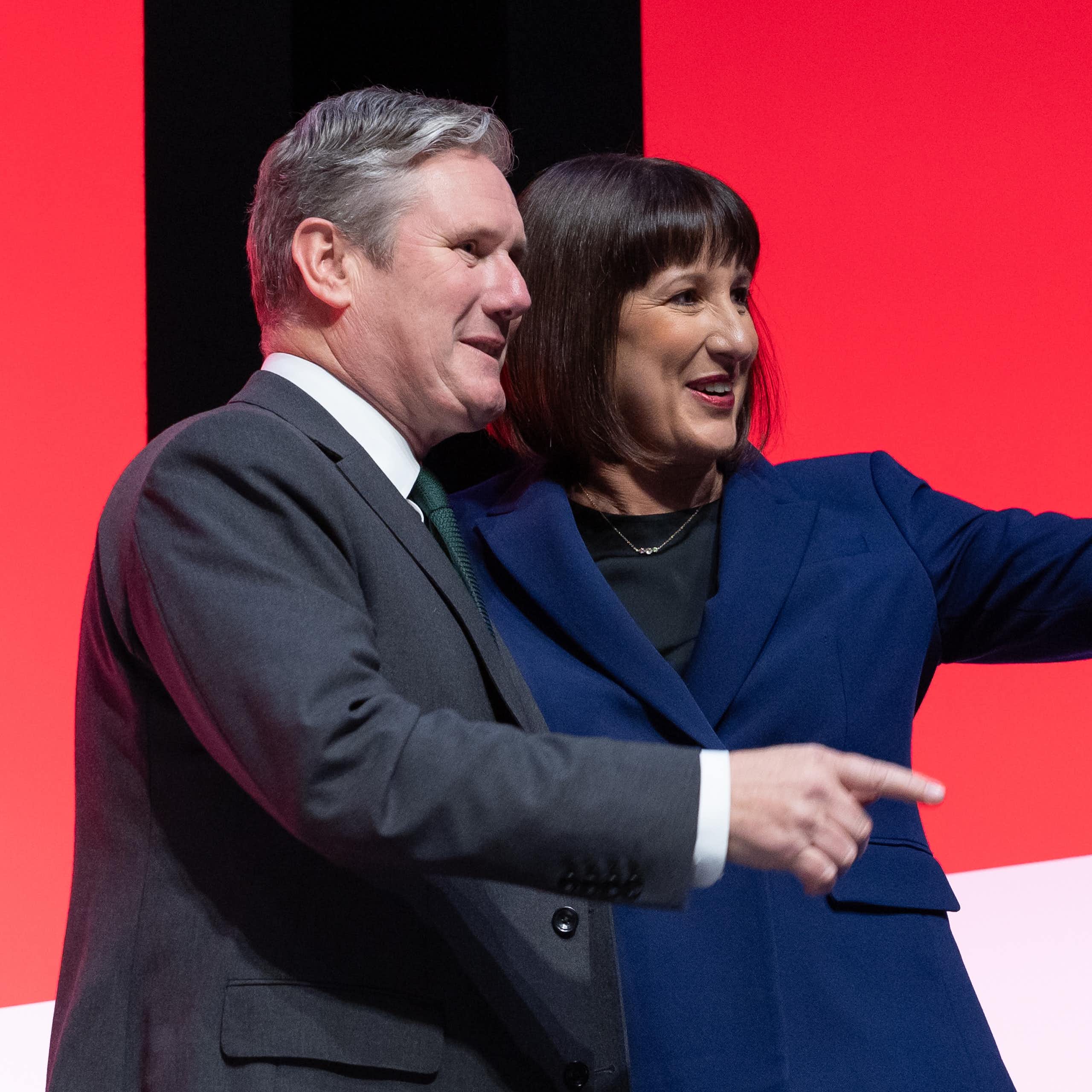 Keir Starmer and Rachel Reeves both pointing and smiling at something off camera