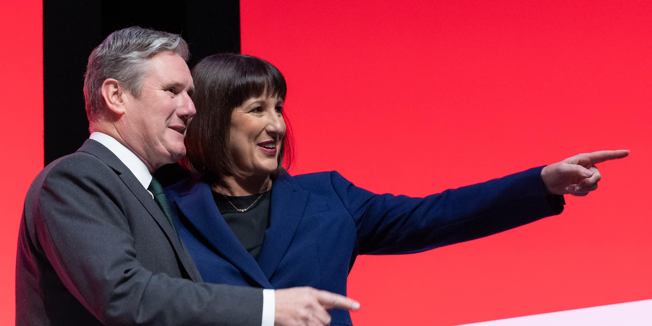 Keir Starmer and Rachel Reeves both pointing and smiling at something off camera