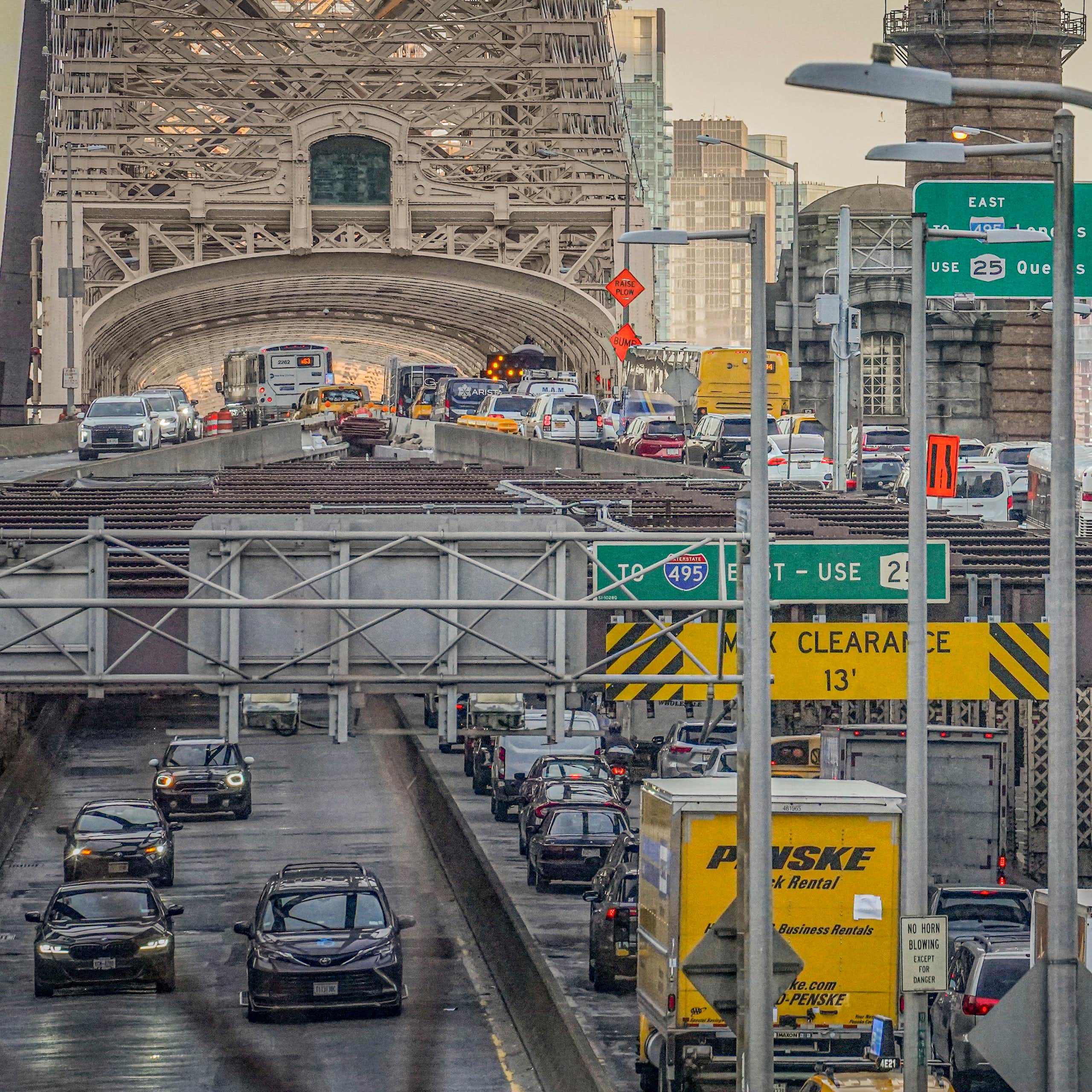 Cars and trucks move across a multi-level bridge in two directions