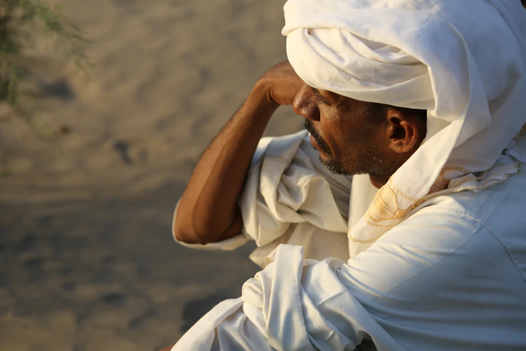 A black man in a white robe and headdress.