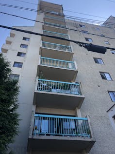 An upward-facing shot of a row of balconies on an apartment building
