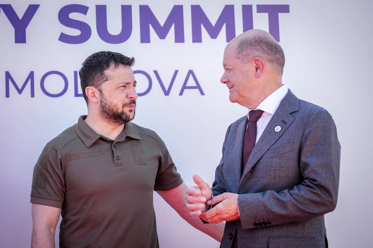 Two men, one in a suit, the other in a polo neck-shirt, meet.