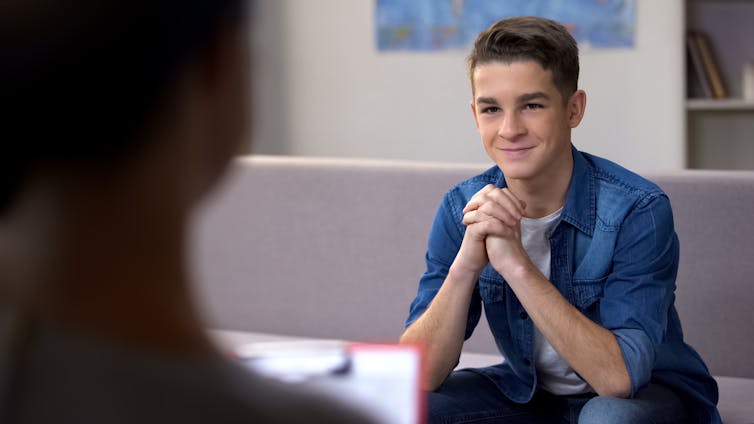 Young person in a therapy session, listening and smiling