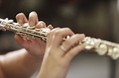 closeup of hands playing flute
