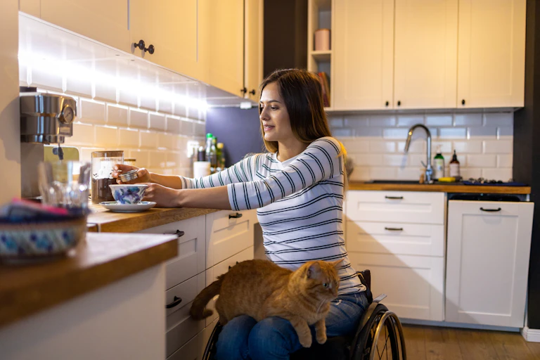 woman in wheelchair makes coffee in her kitchen