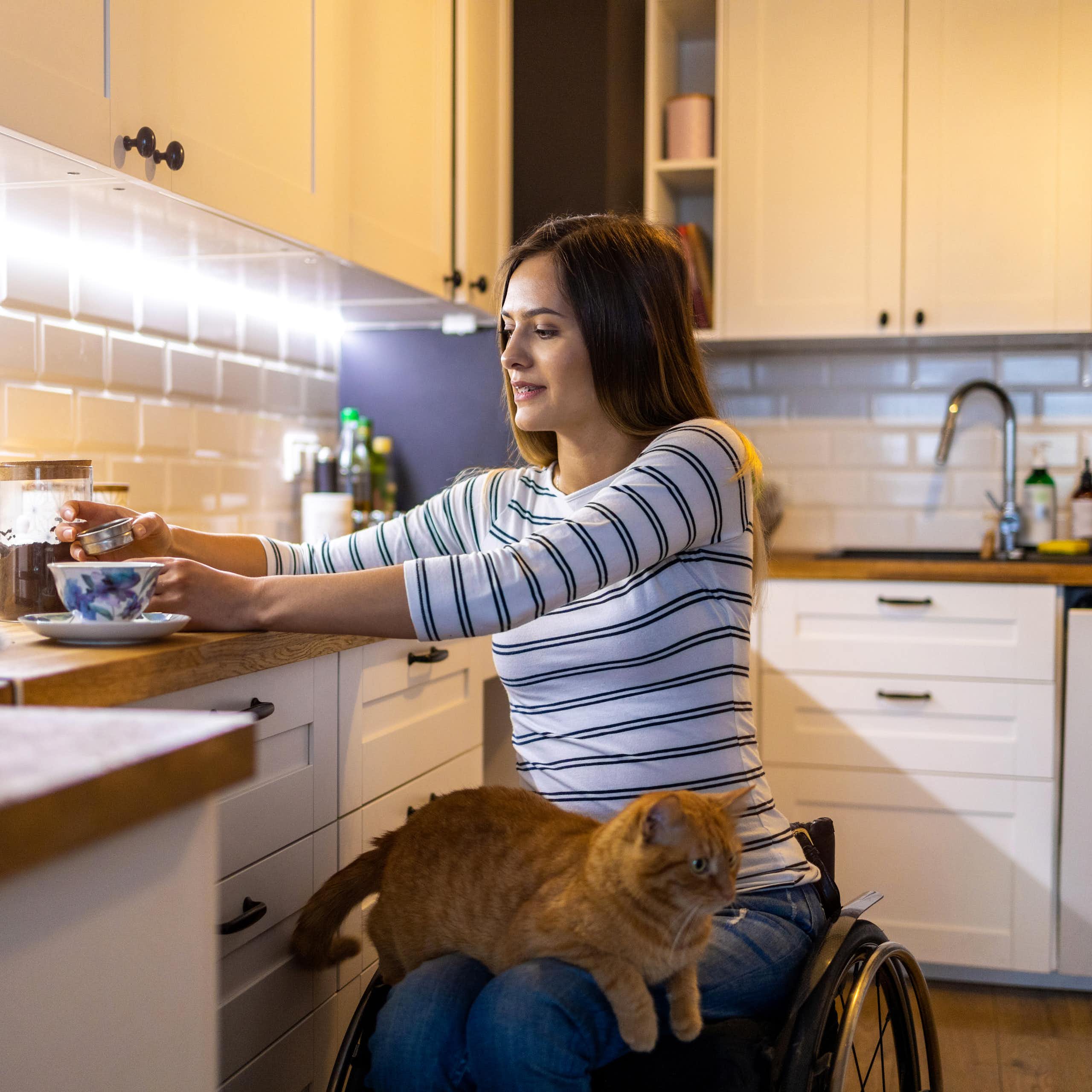 woman in wheelchair makes coffee in her kitchen