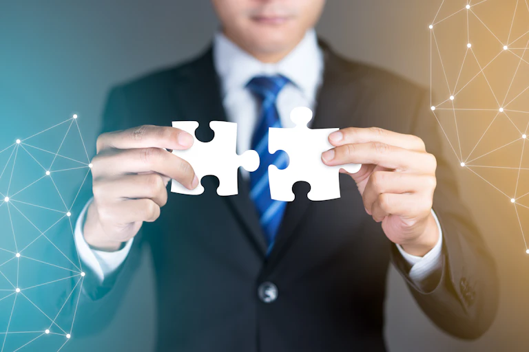 Unidentified man holding two pieces of a jigsaw puzzle