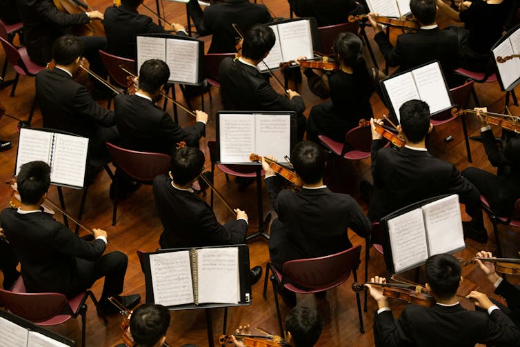 Violinists playing in an orchestra seen from above