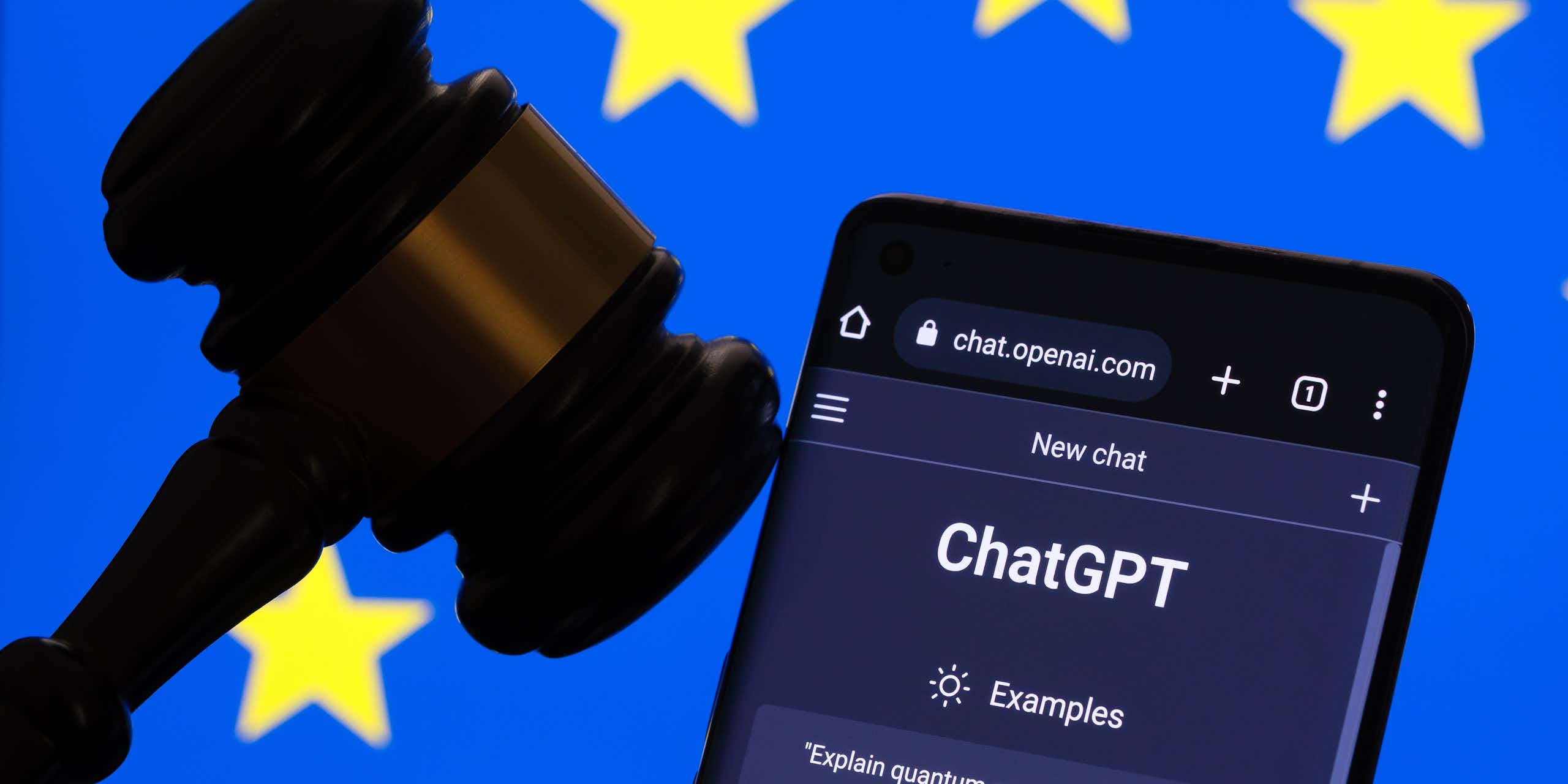 Le site internet de ChatGPT ouvert sur un téléphone, à côté d'un maillet de juge, devant un drapeau européen.