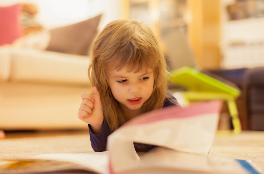 Une petite fille feuilletant un livre