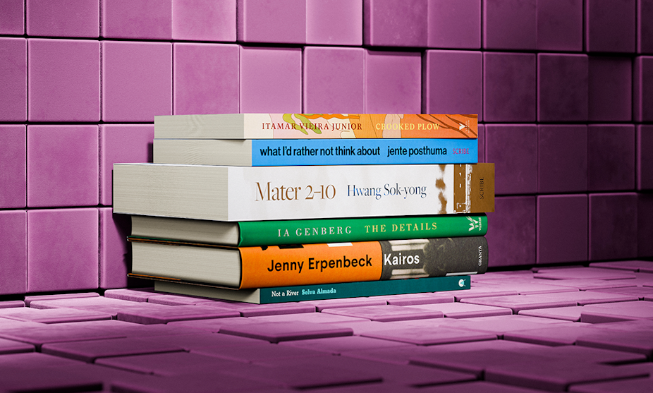Seis libros apilados contra una pared morada