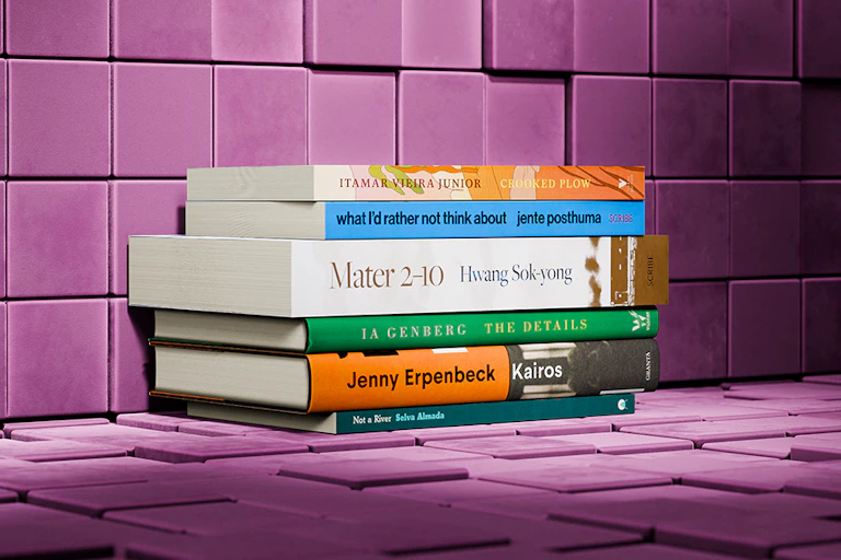 Six books in a pile against a purple wall