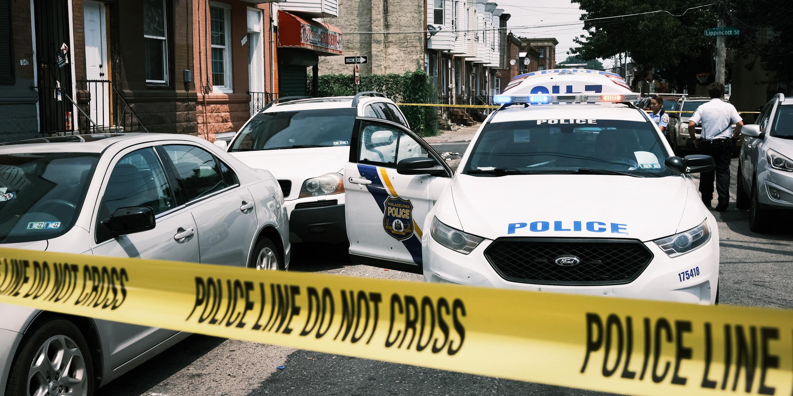 Police tape blocks a street where a person was shot in the Kensington neighborhood of Philadelphia