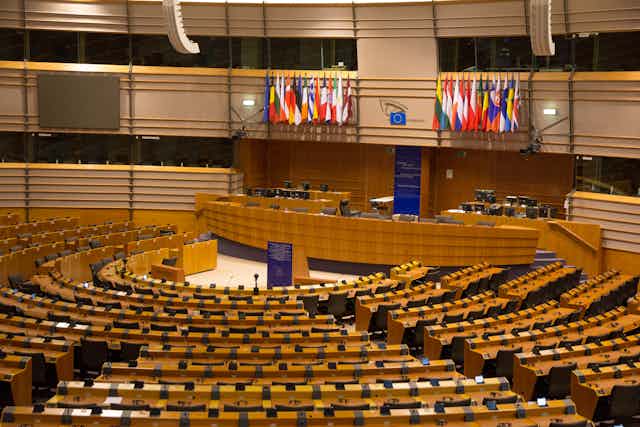 Hemiciclo vacío del Parlamento Europeo en Bruselas con las banderas de los estados miembro.