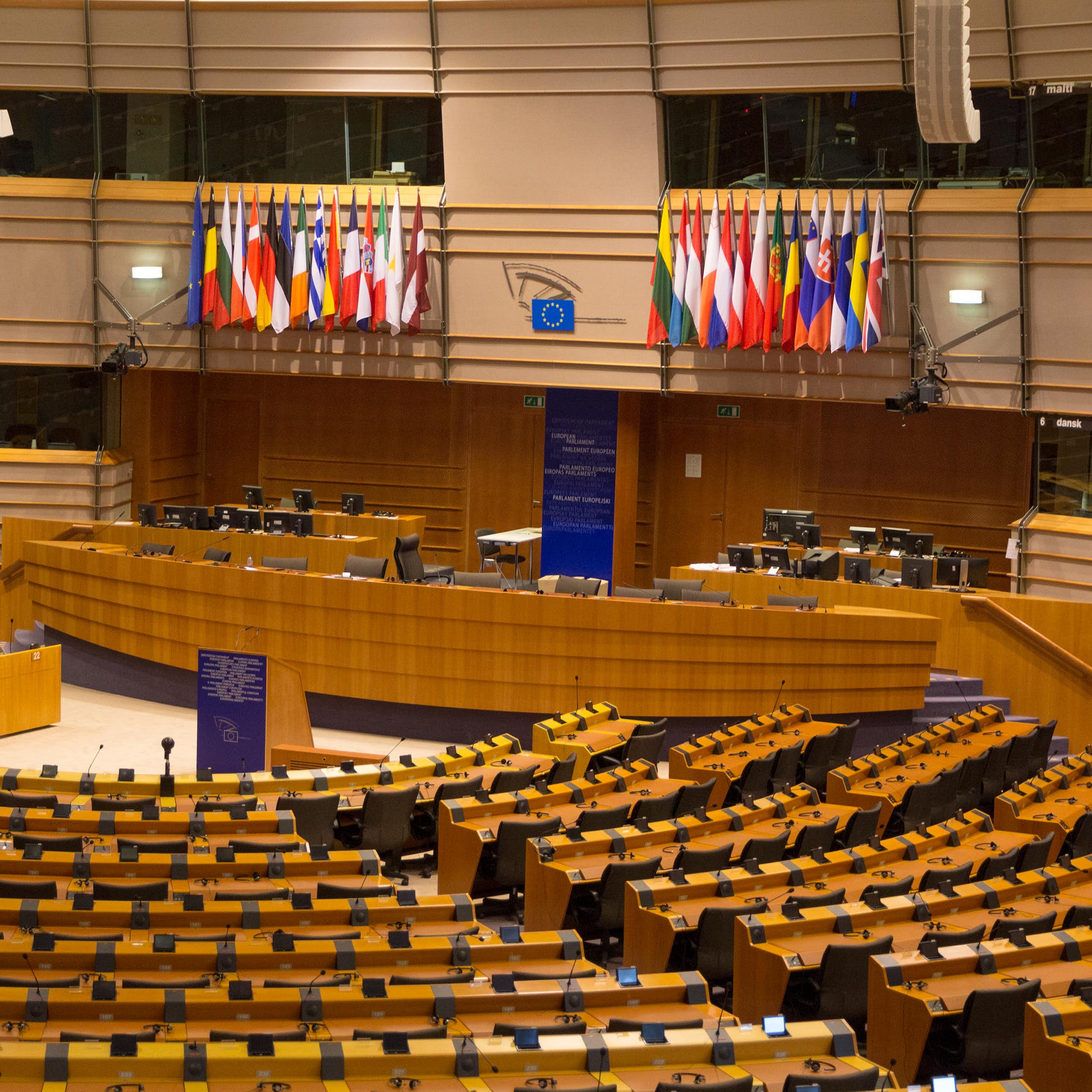 Hemiciclo vacío del Parlamento Europeo en Bruselas con las banderas de los estados miembro.