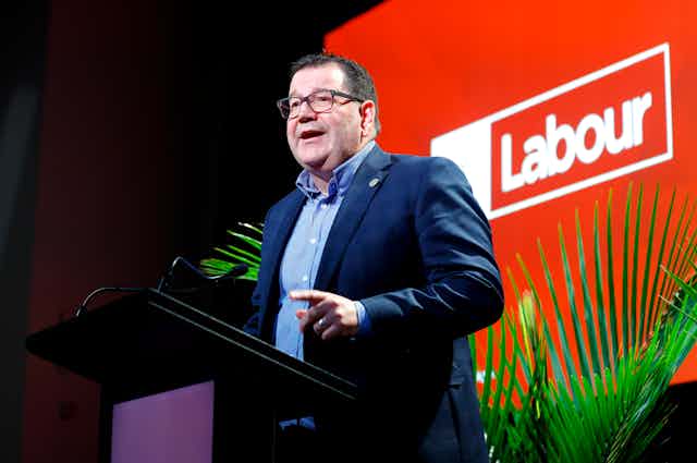 Gratn Robertson speaking in front of a Labour sign