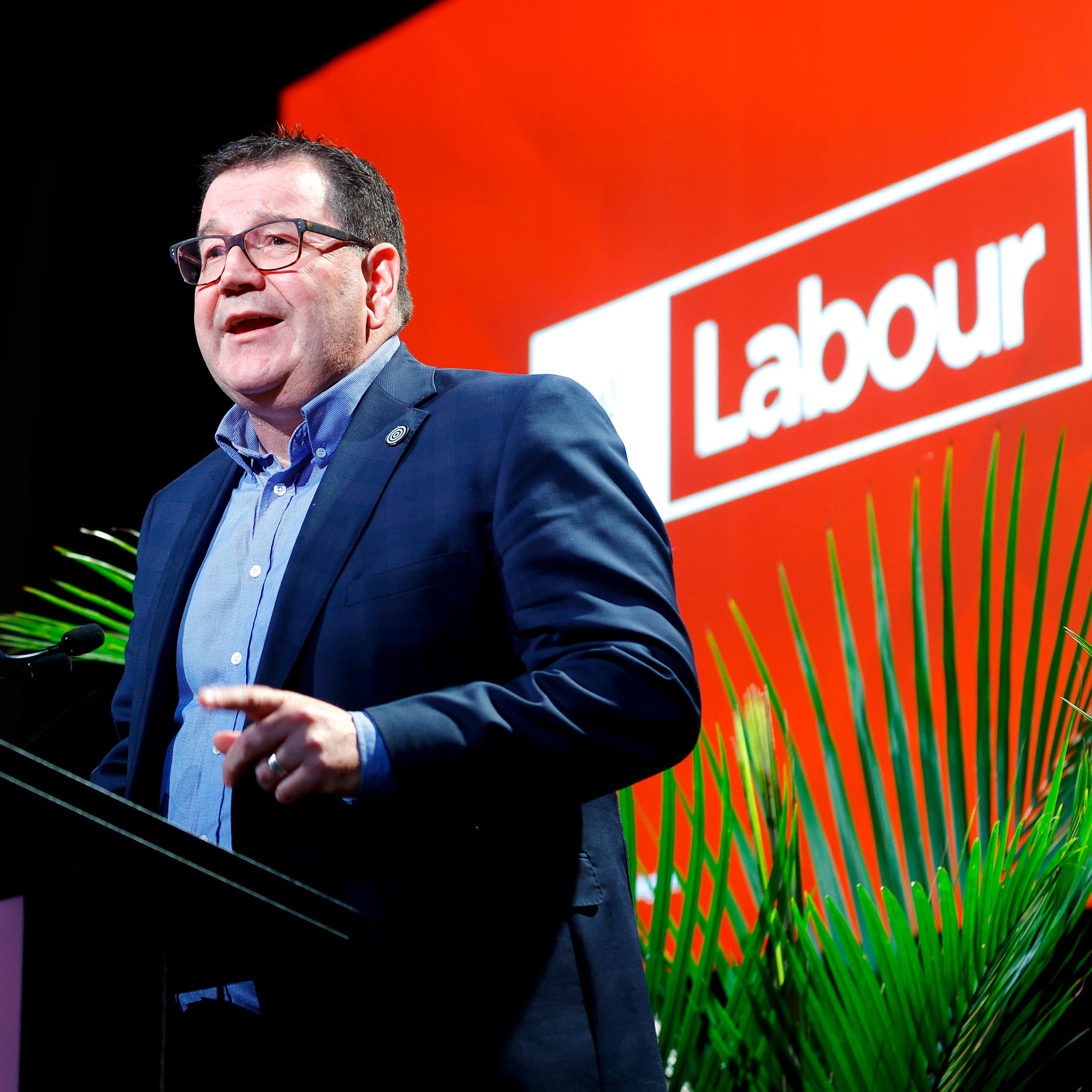 Gratn Robertson speaking in front of a Labour sign