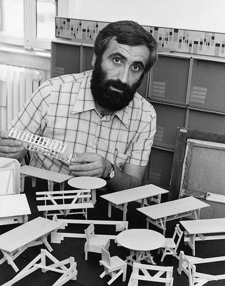 Enzo Mari with small wooden models of tables and chairs