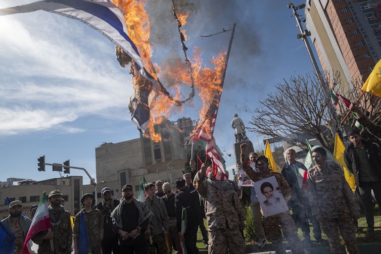 Flames emerge from flags being held by protestors.