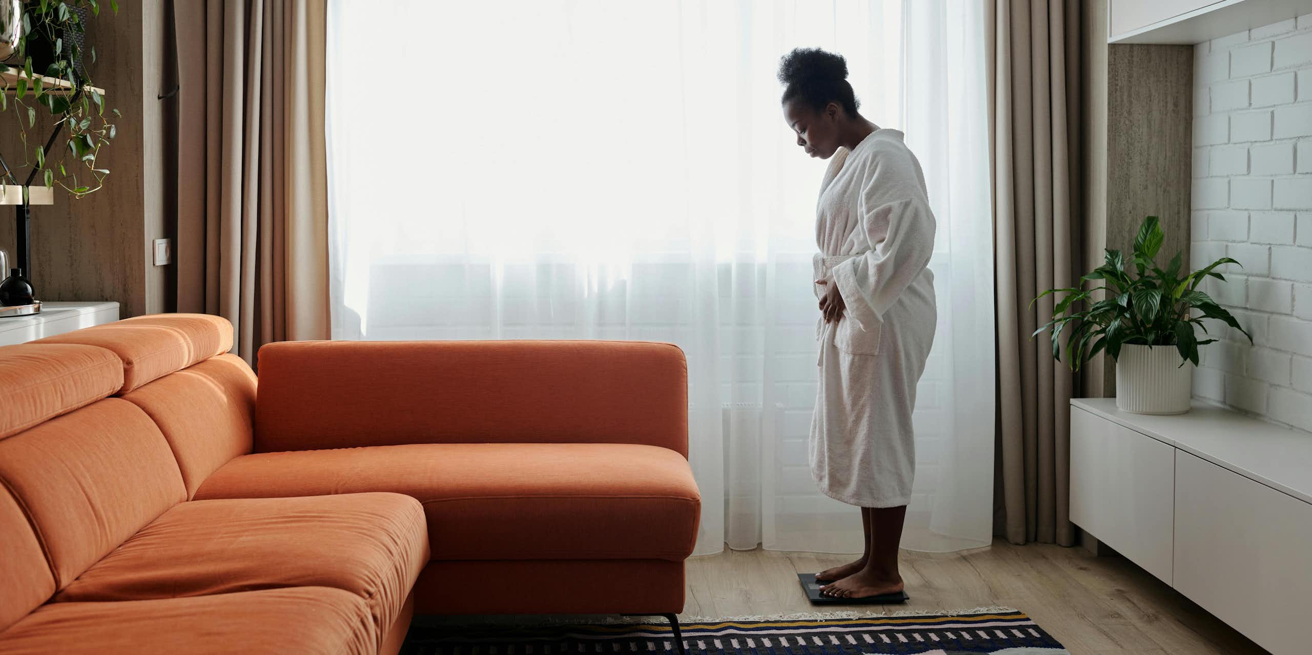 Woman weighs herself in living room